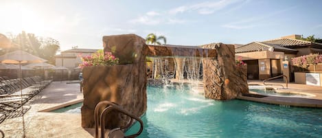 Una piscina al aire libre, sillones reclinables de piscina