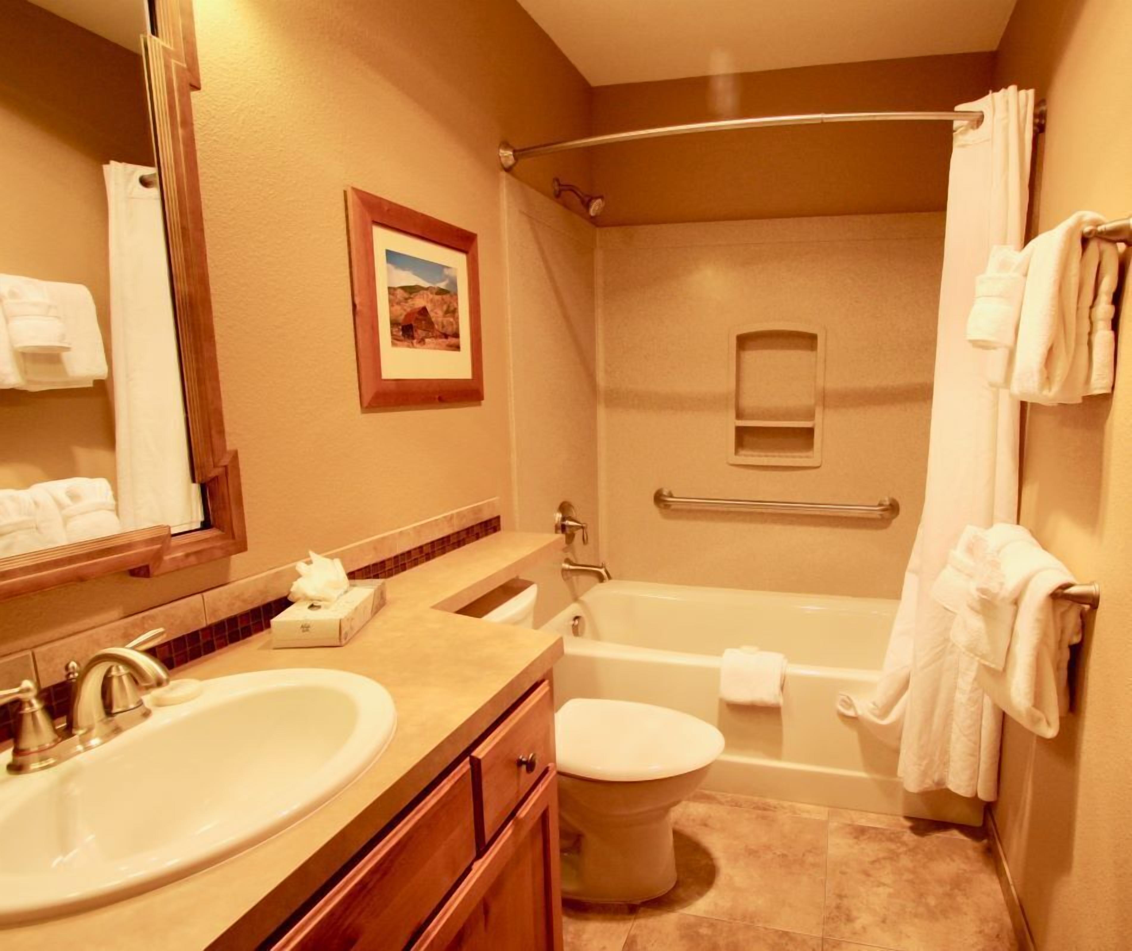 Een badkamer met wastafel, toilet en bad.