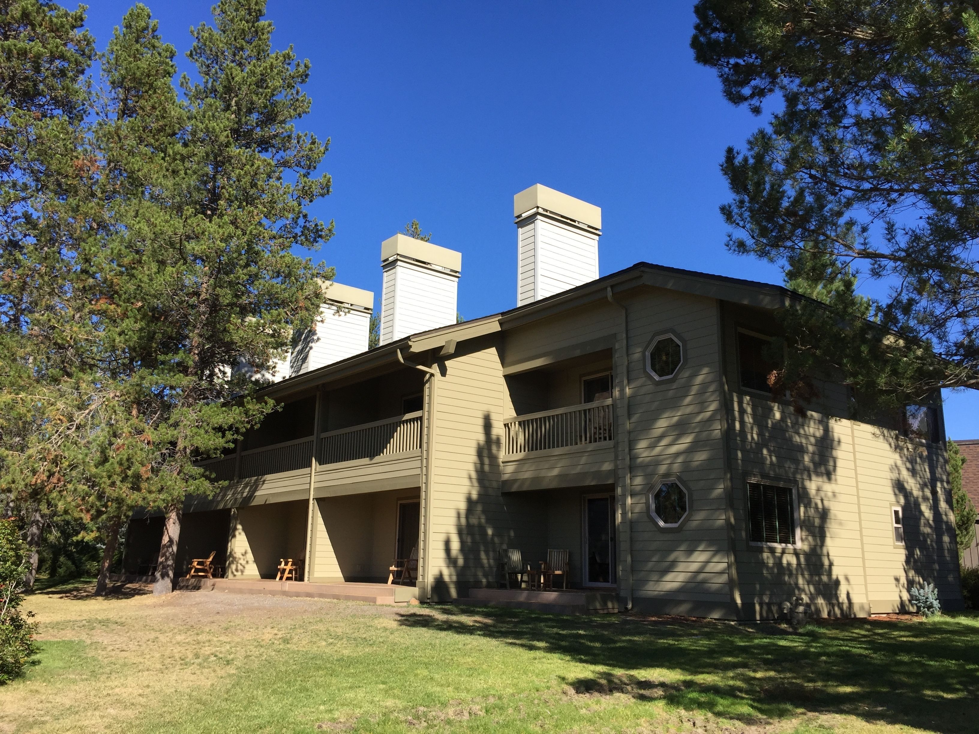 A two-story building with a balcony and a covered porch area.