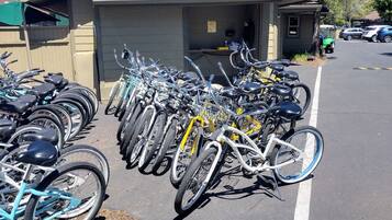 Un aparcamiento para bicicletas con varias bicicletas alineadas frente a un edificio.