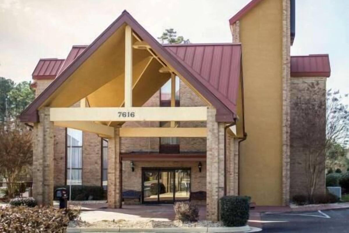 A hotel with a distinctive triangular roof structure, a brick facade, and a large entrance with a canopy.