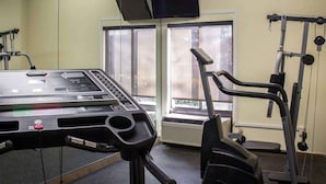 A gym with cardio equipment, a mirrored wall, and a TV on the wall. - Comfort Inn & Suites Fuquay Varina (Fuquay-Varina)