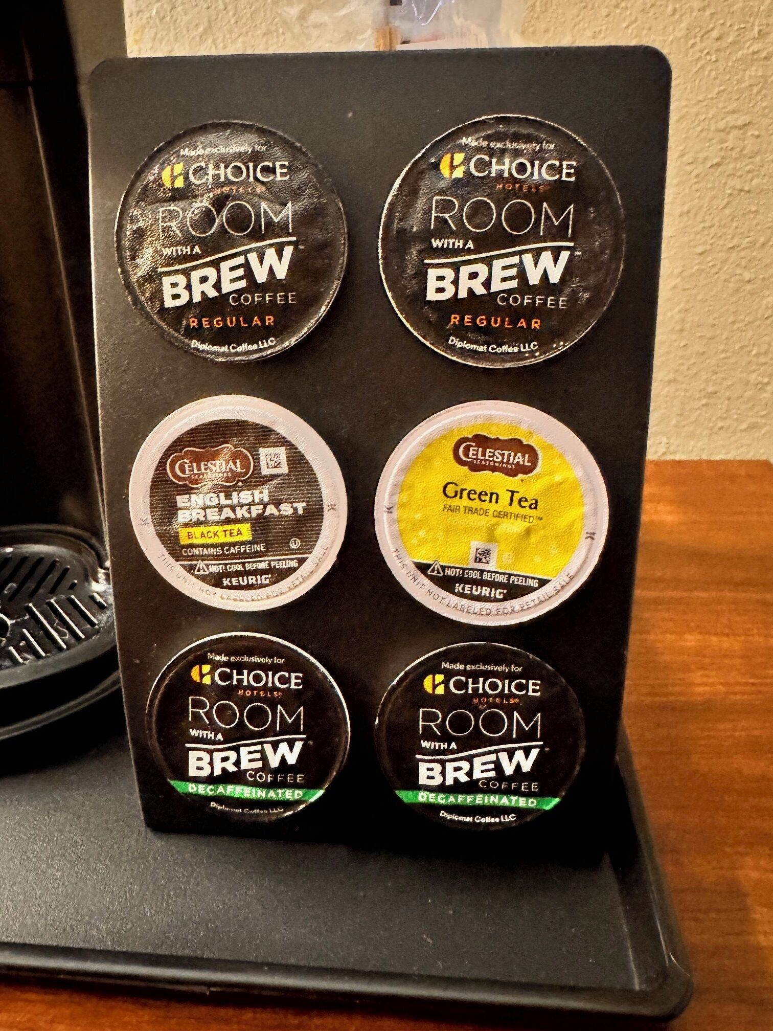 A coffee machine with six coffee pods, including options for regular, decaffeinated, and green tea.