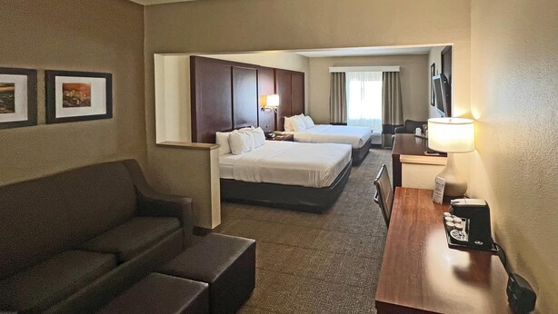 A hotel room with two beds, a sofa, a desk with a lamp, and a TV. - Comfort Suites Peoria Sports Complex (Peoria)
