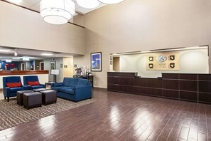 A hotel lobby with a reception desk, blue sofas, and a wooden floor. - Comfort Suites Knoxville Airport (Alcoa)