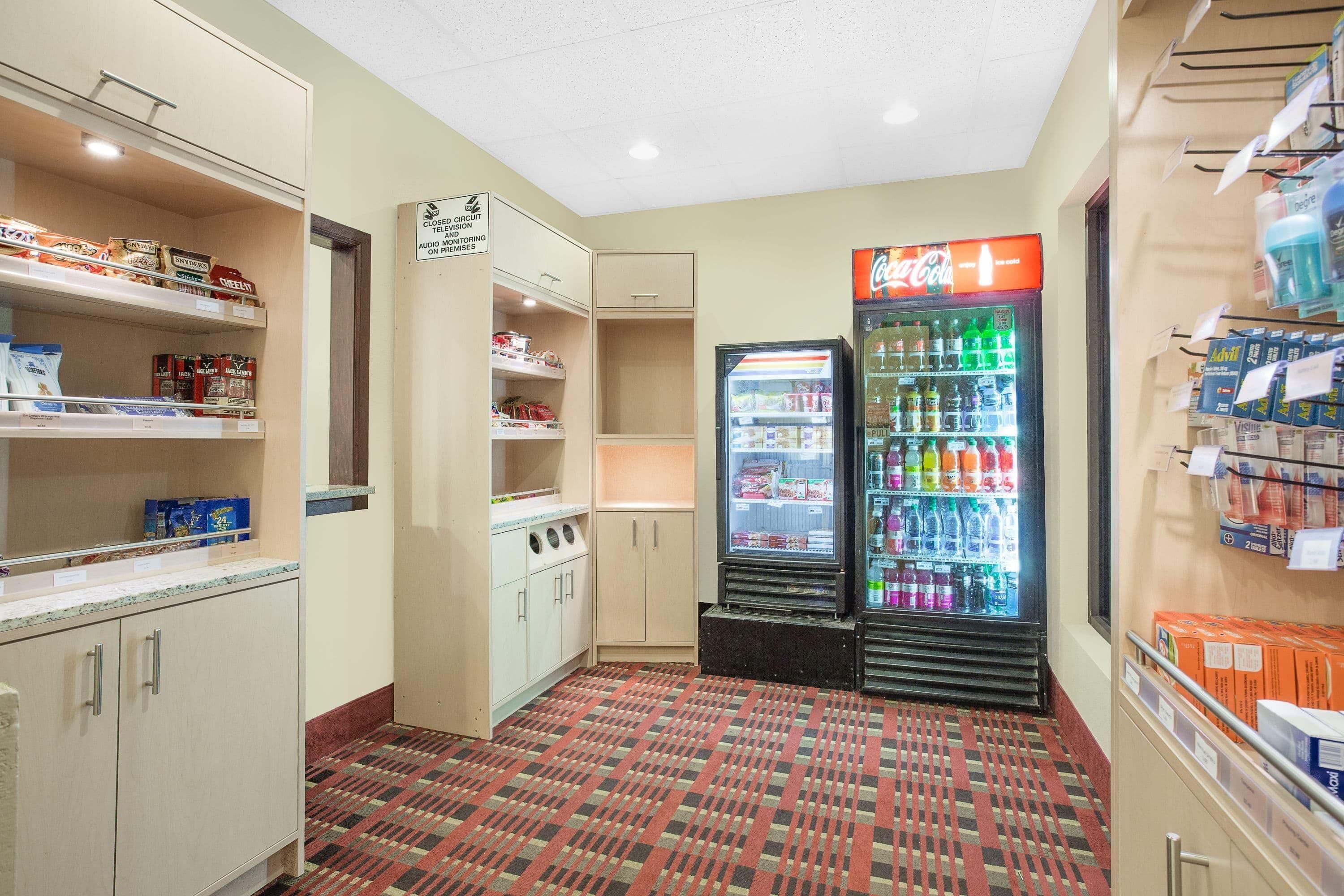 Habitación de hotel con kitchenette, refrigerador y máquina expendedora.