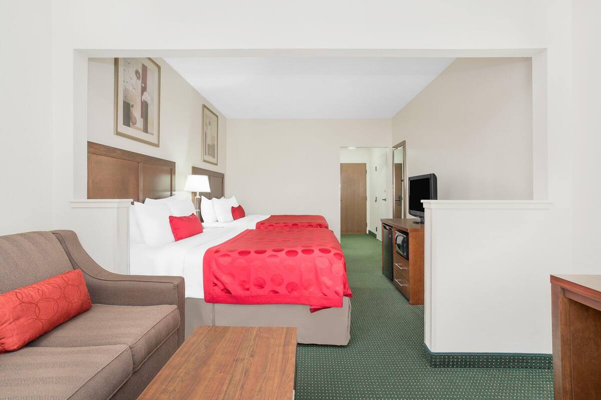 Een hotelkamer met een bed, een bank, een televisie en een bureau.