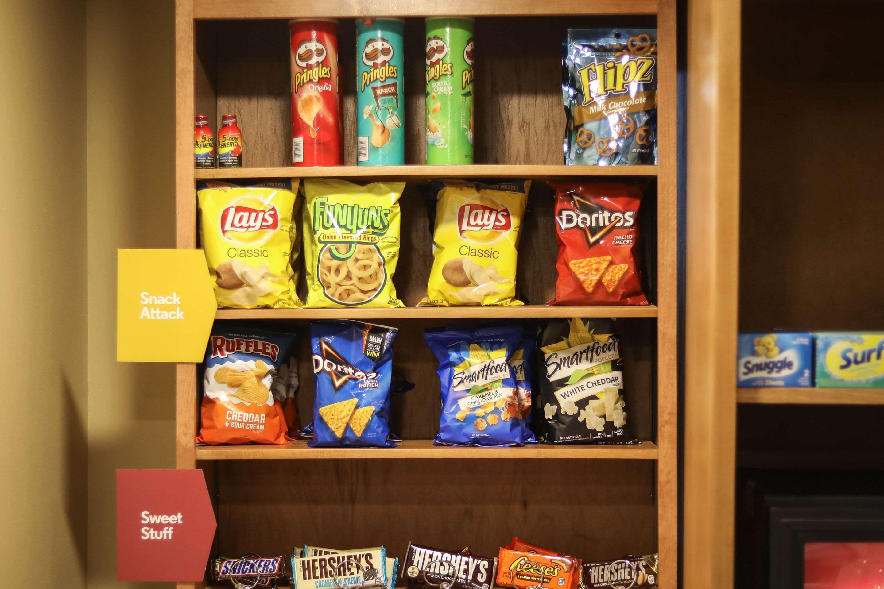 A snack shelf with various chips and candy packages.