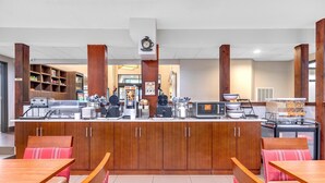 A restaurant with wooden cabinets, a counter with appliances, and red cushioned seating. - Comfort Inn Somerset - Lake Cumberland (Somerset)