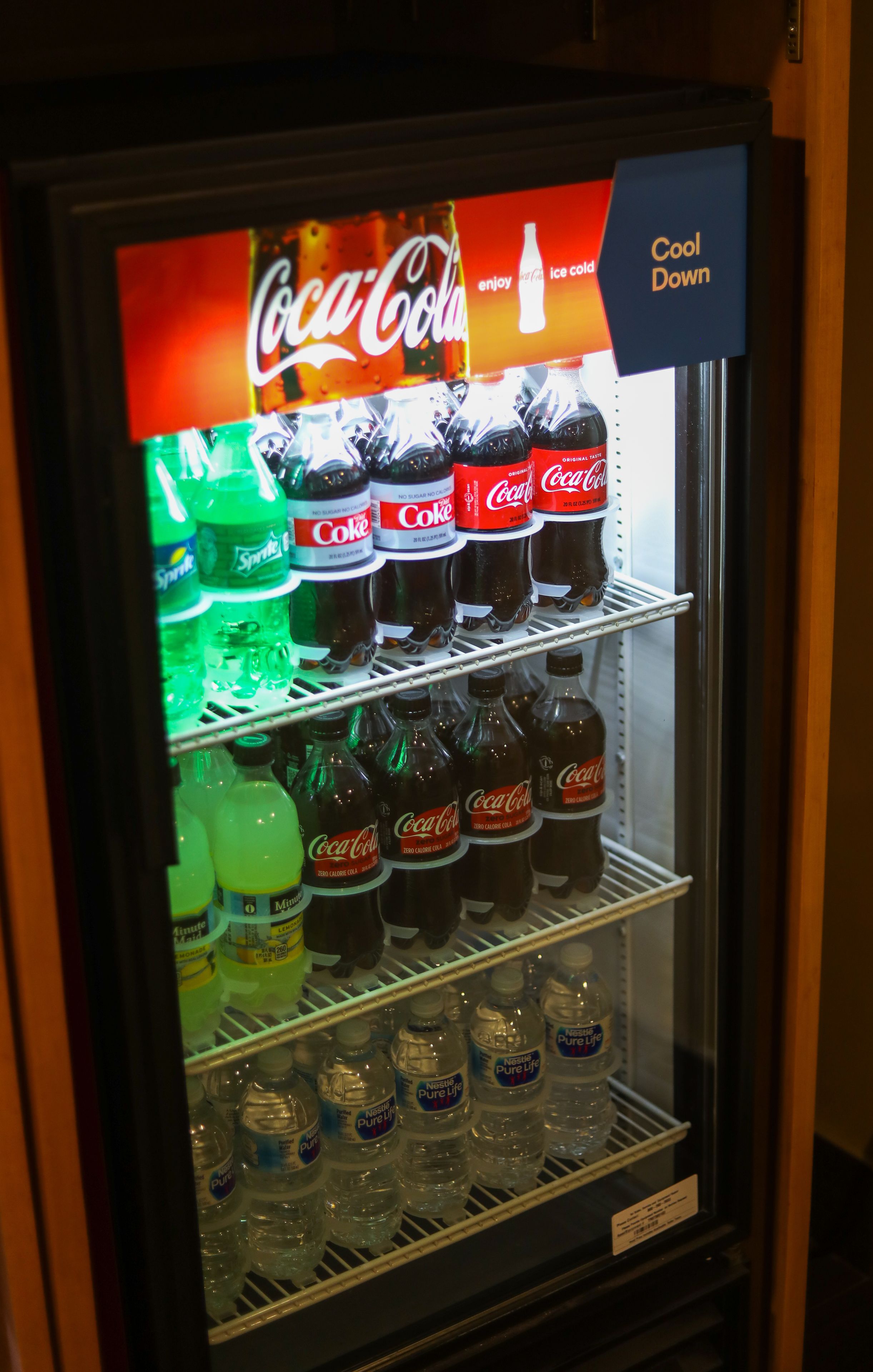 A vending machine stocked with Coca-Cola, Sprite, and water bottles.