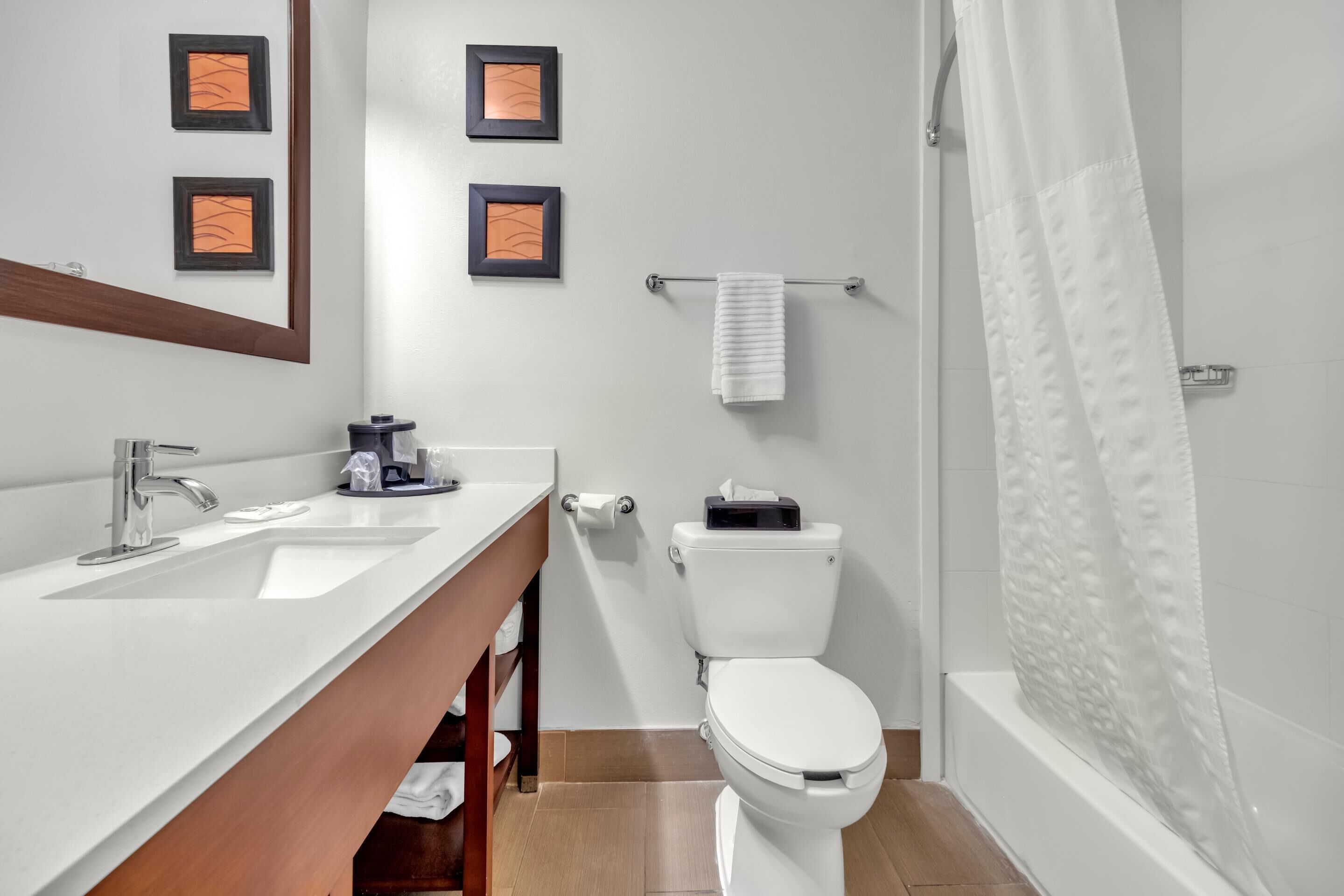 Un baño moderno con un lavabo blanco, inodoro y ducha.