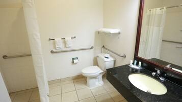 A bathroom with a white toilet, a sink with a mirror, and a shower curtain.