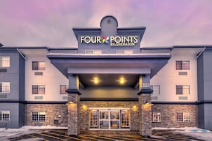 Entrada de un hotel con un letrero que dice 'Four Points by Sheraton' y el número '325' en el edificio.