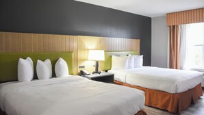 A hotel room with two beds, a green headboard, a nightstand with a lamp, and a window with curtains. - Country Inn & Suites by Radisson, Bloomington-Normal West, IL (Bloomington)