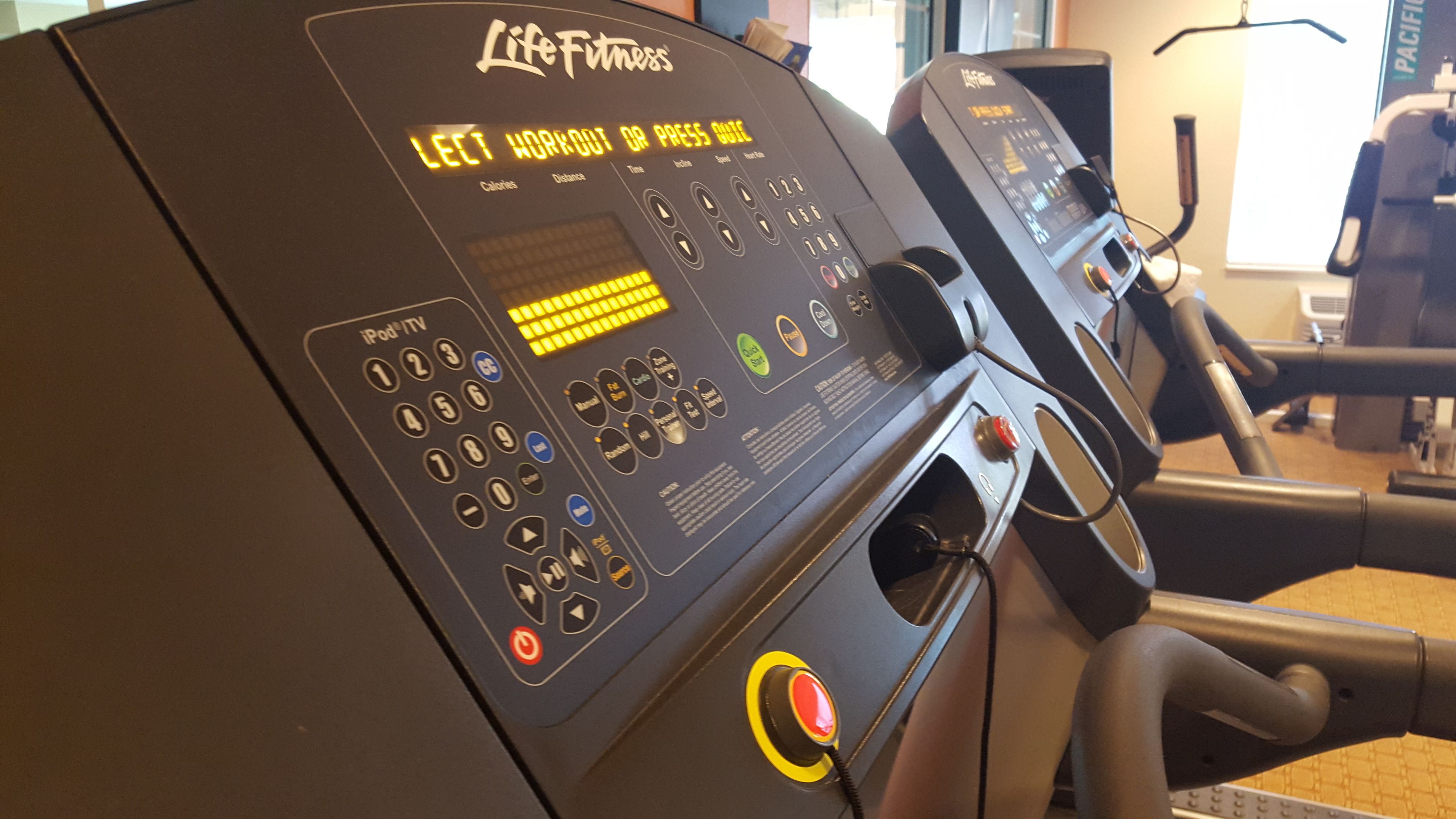 Un tapis roulant Life Fitness con display digitale, pannello di controllo e pulsante di sicurezza.