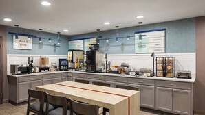 A modern kitchen with a central island, built-in appliances, and a chalkboard menu. - Garner Hotel Phoenix Northwest – Surprise by IHG (Surprise)