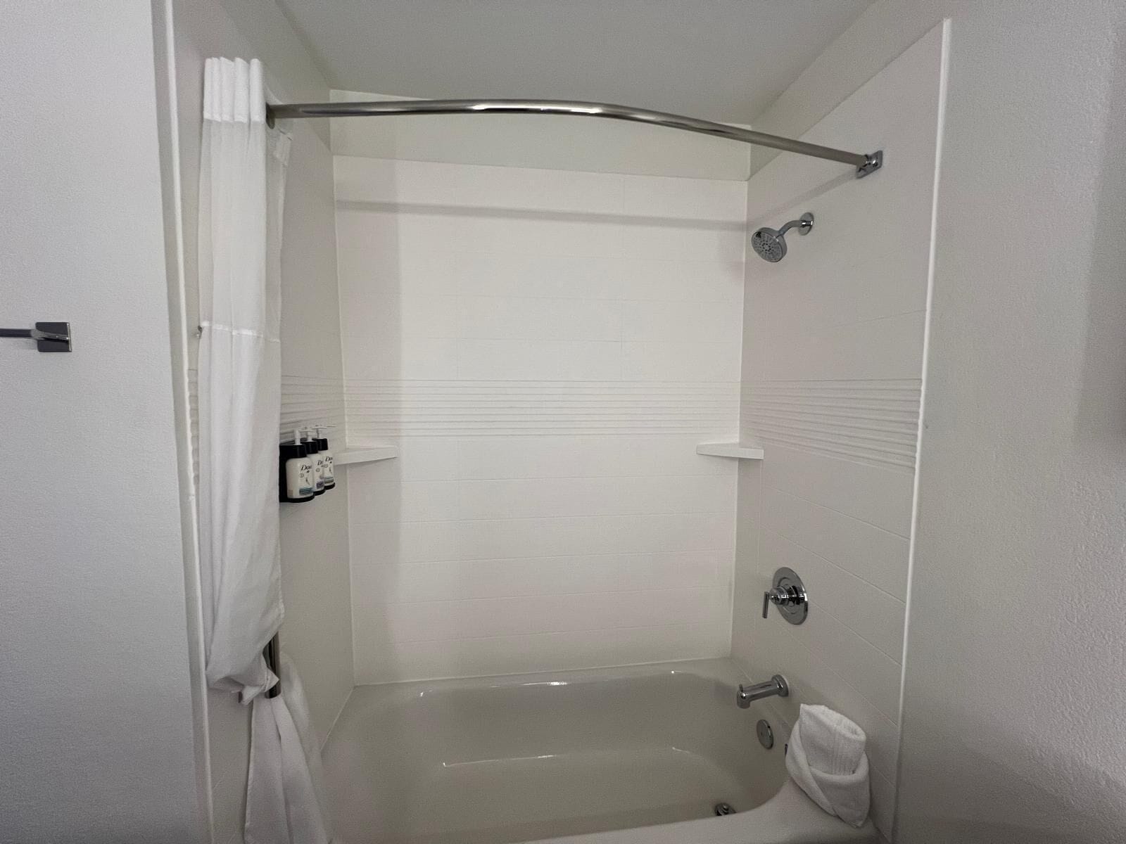 A modern bathroom with a bathtub, shower, and toilet.