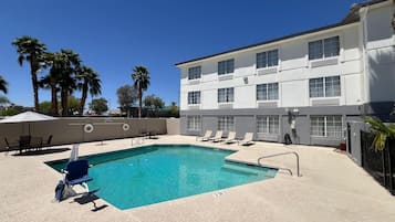 Relax by the pool surrounded by comfortable lounge chairs and umbrellas.