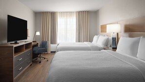 A hotel room with two beds, a desk with a television, and a lamp. - Garner Hotel Phoenix Northwest – Surprise by IHG (Surprise)