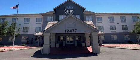 A hotel with a prominent 'Garner' sign, a large entrance number '12477', and a flagpole with an American flag.