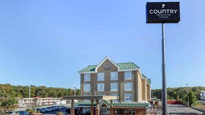 Ein Country Inn & Suites Hotel mit großem Parkplatz, überdachter Eingangsparte und gut sichtbarer Beschilderung.