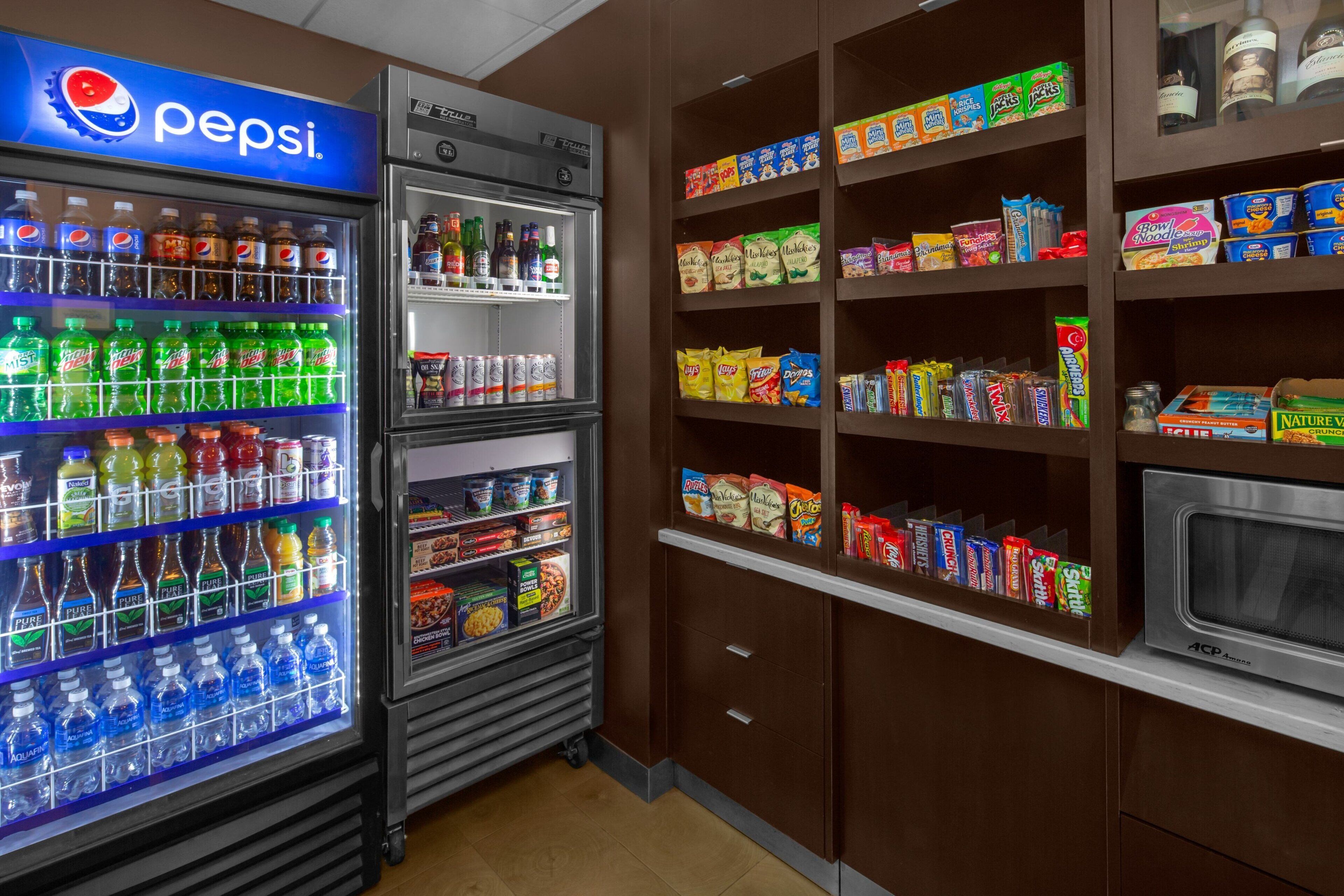 Un espace équipé de distributeurs automatiques proposant des produits Pepsi et diverses collations.