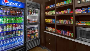 Un espace équipé de distributeurs automatiques proposant des produits Pepsi et diverses collations.