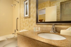 A bathroom with a granite countertop sink, a mirror, a towel rack, and a shower area. - Comfort Inn Downtown DC/Convention Center (Washington)