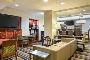 A hotel lobby with seating, a television, and a waste bin. - Comfort Inn Downtown DC/Convention Center (Washington)