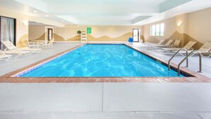 Una piscina con sillones de descanso y una escalera.
