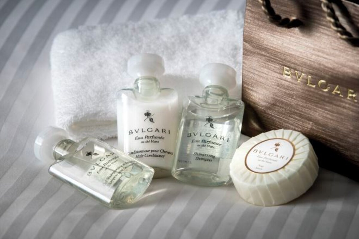 Trois flacons de parfum BVLGARI et un savon BVLGARI sur une surface à rayures.