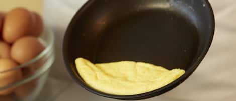 A person cooking an omelette in a pan.