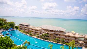 Alberca al aire libre, sombrillas en la alberca y camastros