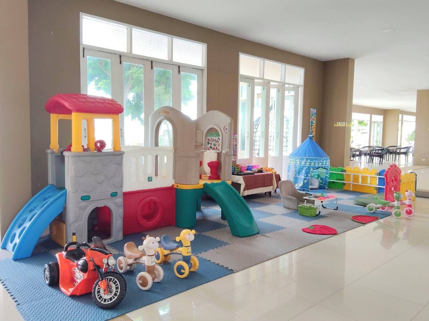 A children's play area with a slide, climbing structure, and various toys.