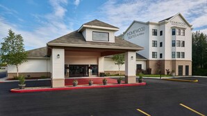 A hotel with a covered entrance, a red carpet, and a parking lot. - Homewood Suites by Hilton Anchorage (Anchorage)