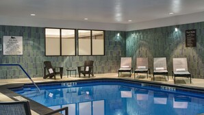 A swimming pool area with lounge chairs and a sign detailing pool rules. - Homewood Suites by Hilton Anchorage (Anchorage)