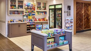 A well-stocked grocery store with shelves of snacks, a refrigerated section, and a display of children's books. - Homewood Suites by Hilton Anchorage (Anchorage)