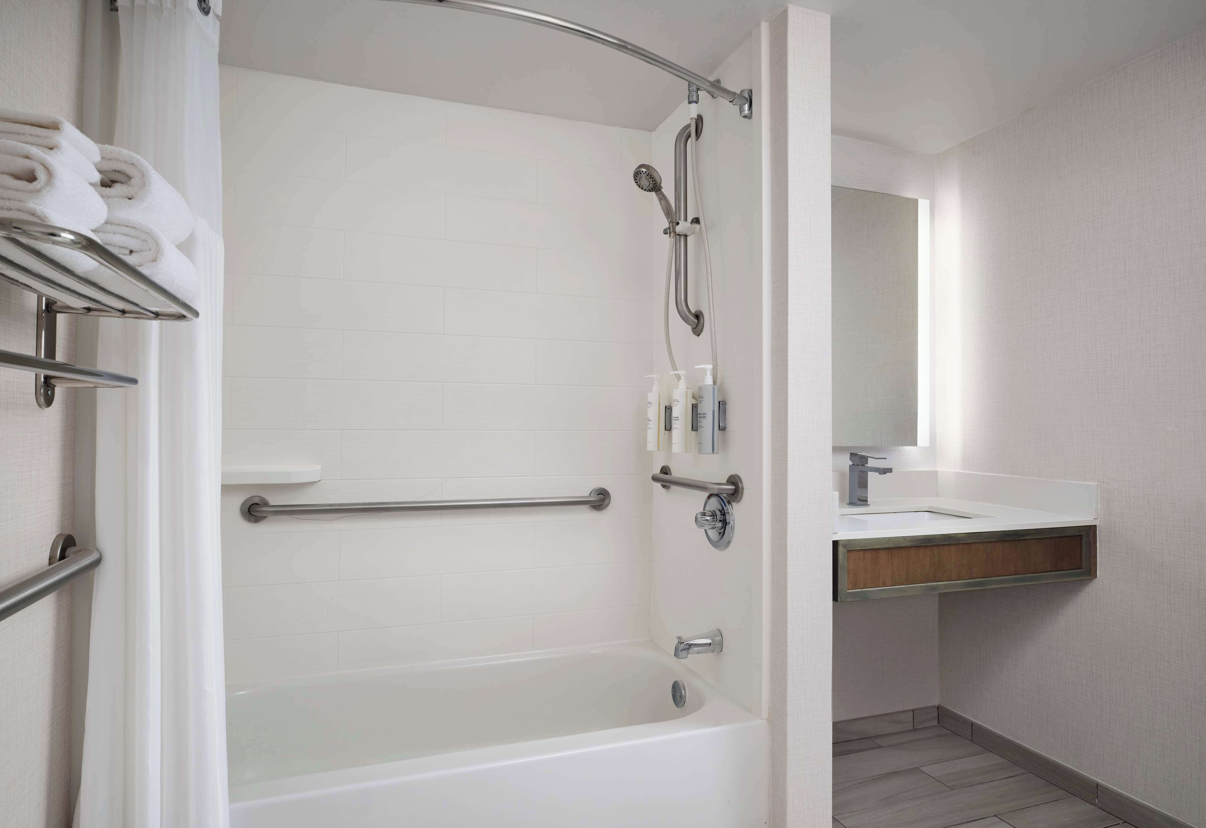 combined shower/bathtub, designer toiletries, hair dryer, towels