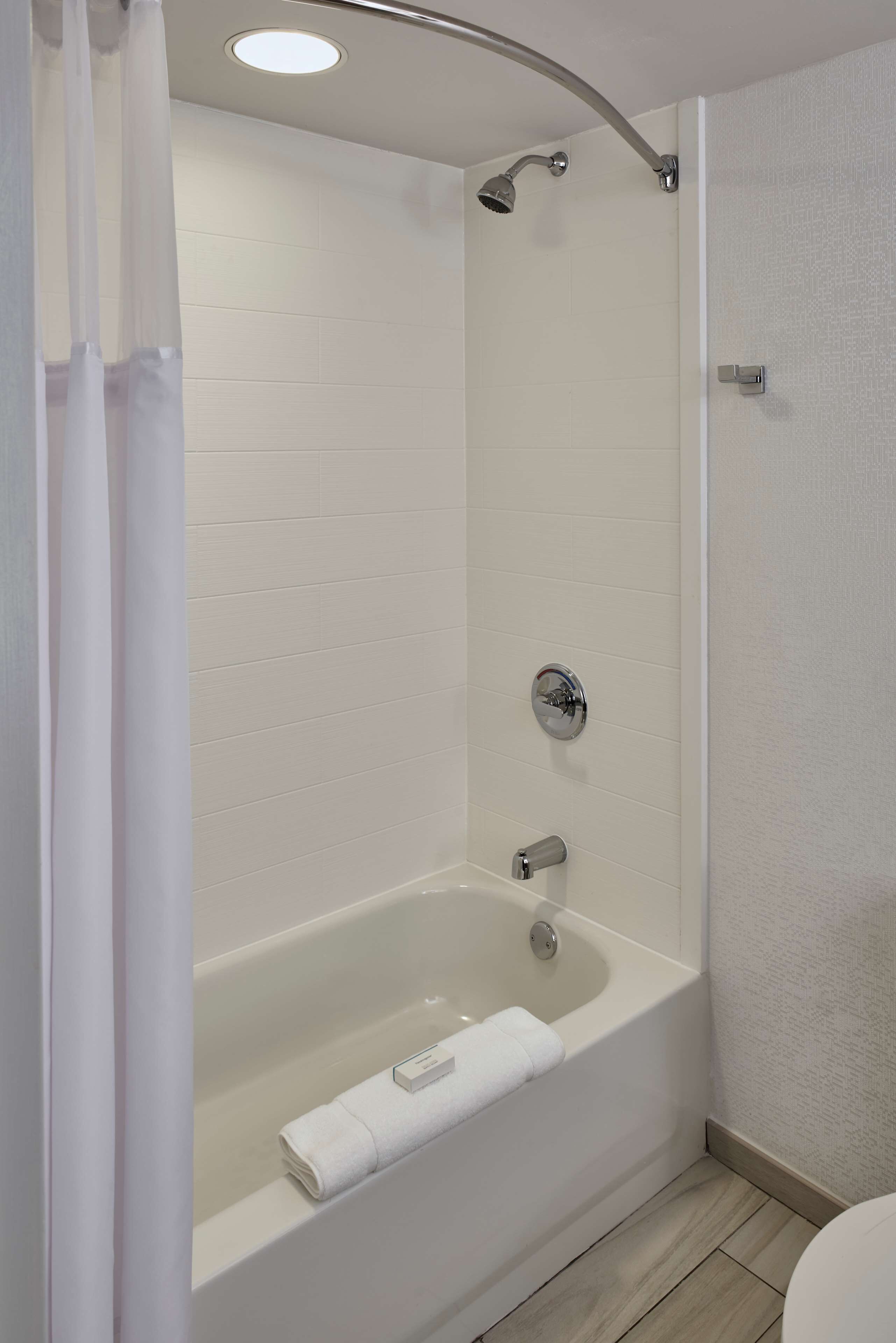 A modern bathroom with a freestanding bathtub, a showerhead, and a towel rack.