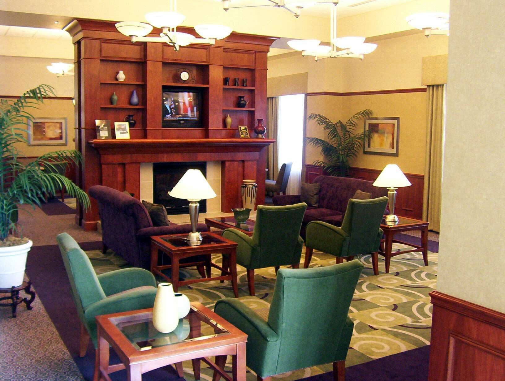 Un hall de hotel con chimenea, asientos cómodos y un televisor.
