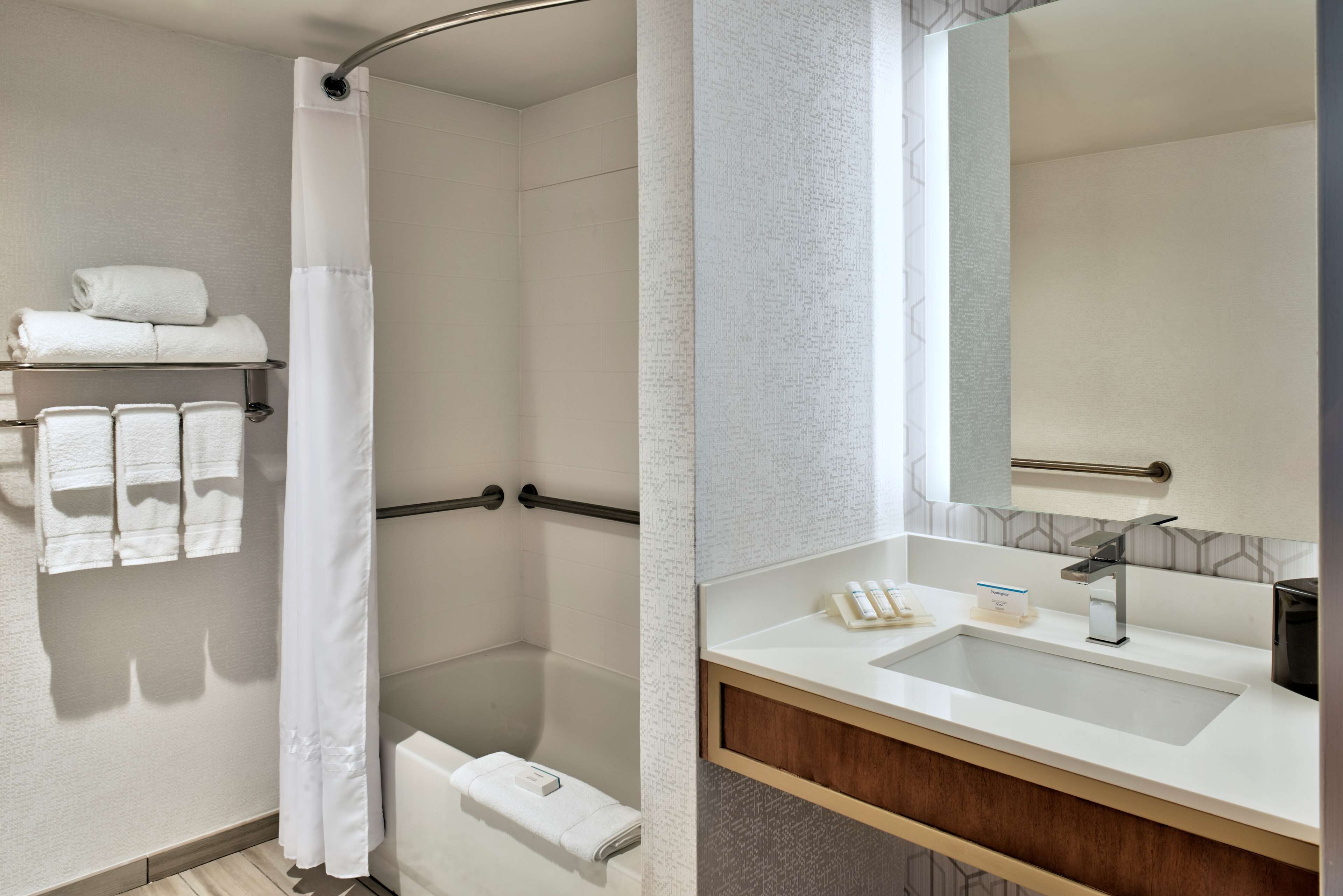 Une salle de bain moderne équipée d’une douche, d’un lavabo et d’un porte-serviettes.