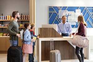 A reception desk with a blue geometric wall design, a counter, and a sign that reads 'Holiday Inn Express & Suites'. - Holiday Inn Express Hotel & Suites Richmond-Brandermill by IHG (Midlothian)