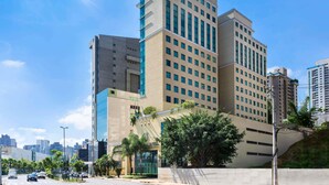 A multi-story hotel with a modern architectural design, featuring a prominent glass facade and a flat roof. - Caesar Business Belo Horizonte Belvedere Managed by Mercure (Belo Horizonte)