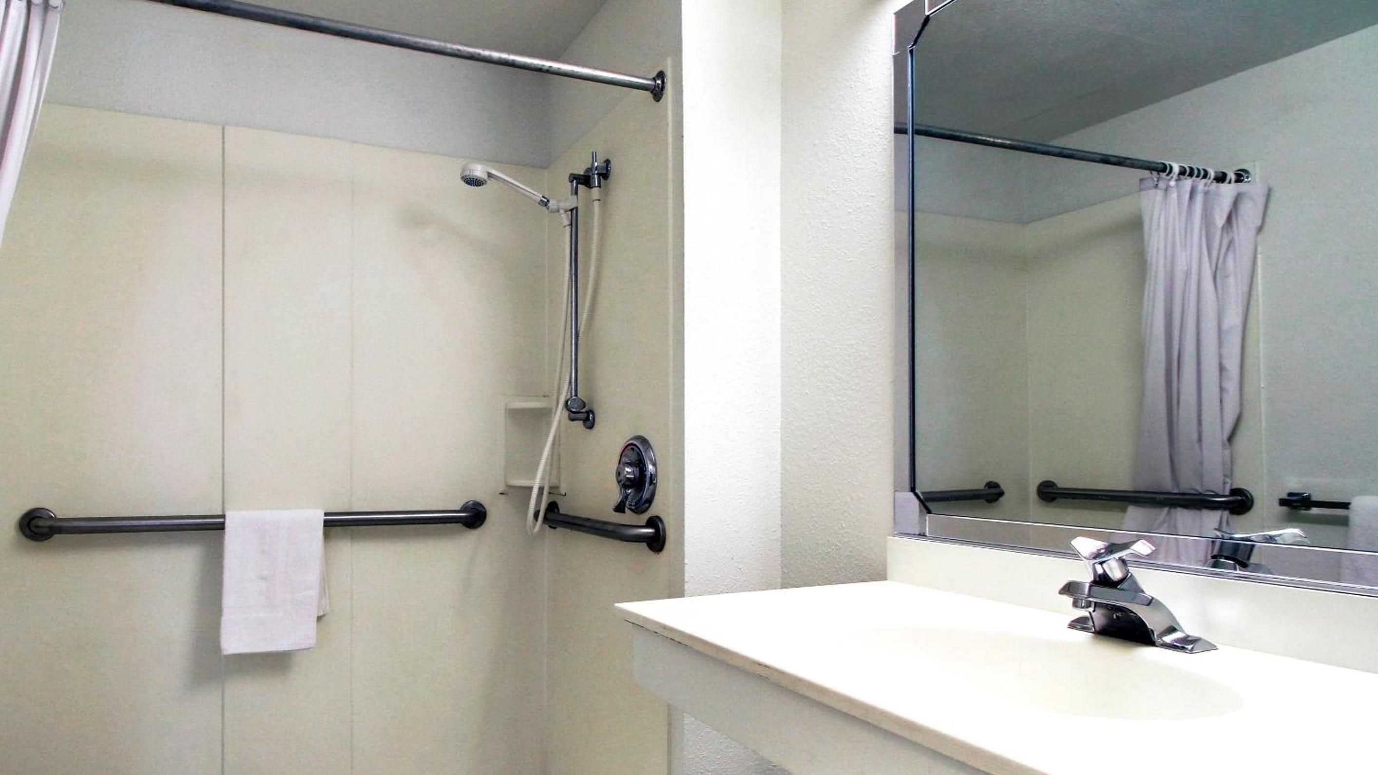 A bathroom with a shower, a toilet, and a sink.
