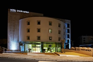 Un hotel de diseño moderno, con fachada curva, varias ventanas y un letrero llamativo.