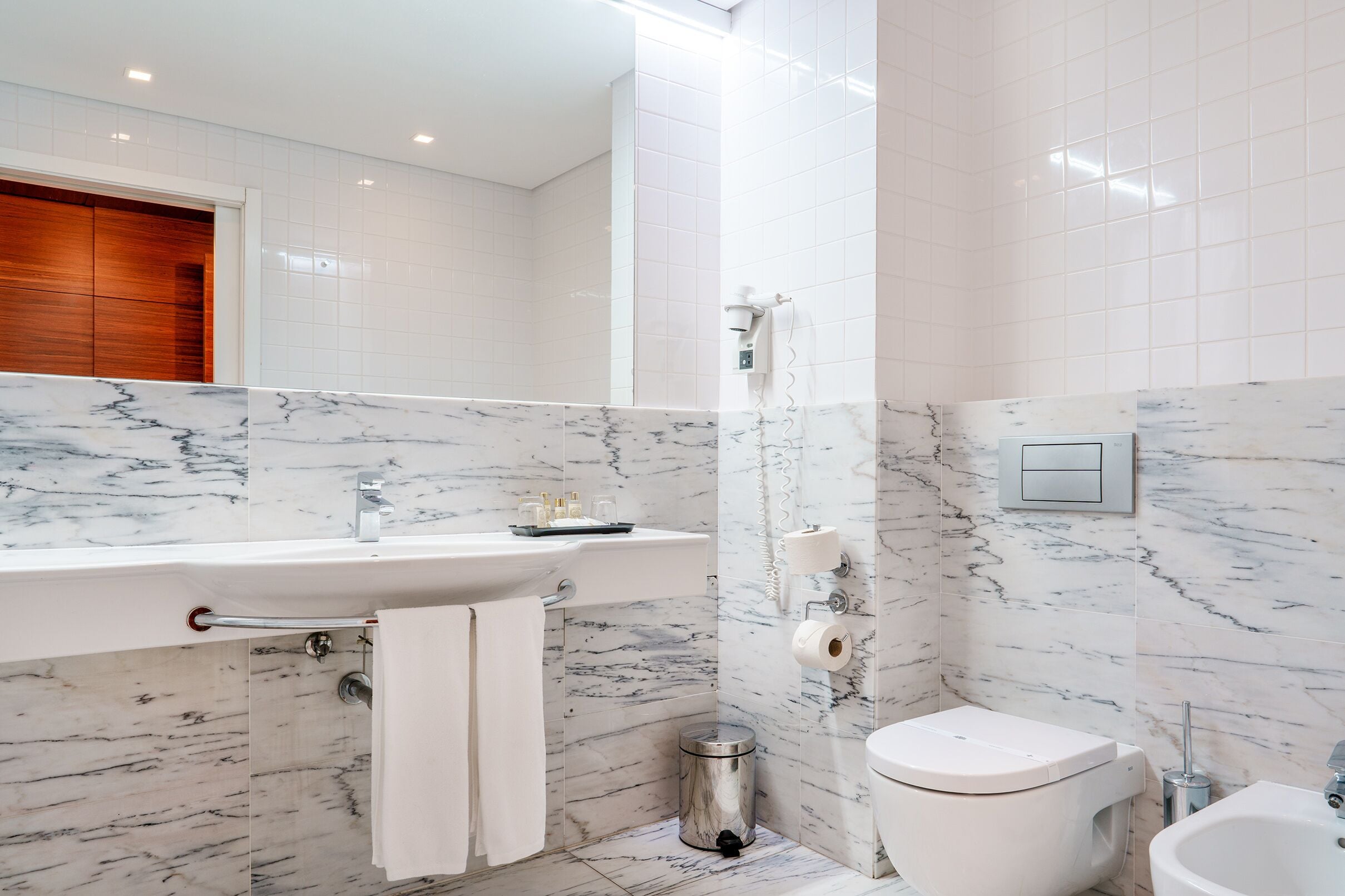 Un baño moderno con tocador de mármol, inodoro y bidé.