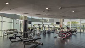 Una palestra con diverse attrezzature per esercizi, ampie finestre e un design moderno e pulito.