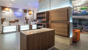 A reception area with a wooden reception desk, a glass partition, and a seating area with sofas.