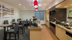 A modern kitchen with a central island, a dining area with chairs and tables, and a large window providing natural light. - TownePlace Suites by Marriott Sunnyvale Silicon Valley (Sunnyvale)
