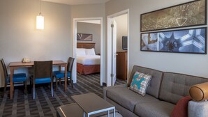 A hotel room with a bed, a sofa, a desk with chairs, a television, and artwork on the wall. - TownePlace Suites by Marriott Sunnyvale Silicon Valley (Sunnyvale)